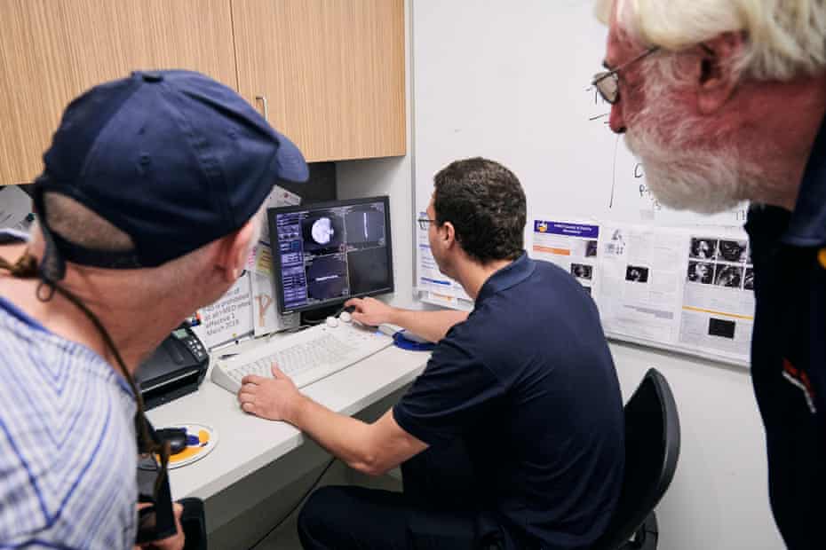 Regional Imaging chief radiographer Jack Feeney works on the image of the coin from the CT scanner as archaeologist Mike Hermes and historian Mike Owen watch on.