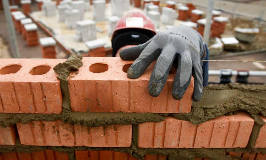 A construction worker lays bricks 