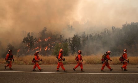 Firefighters walk along highway 20 as they monitor the Rocky Fire near Clearlake on Sunday. 