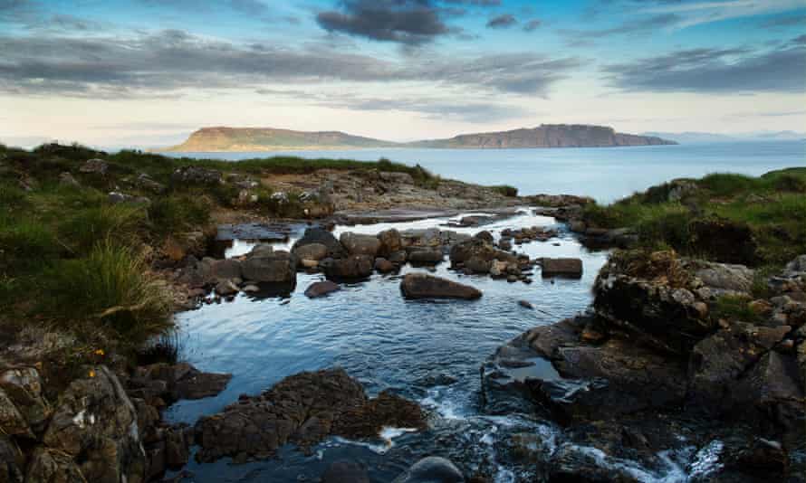 A waterfall flows along a small gorge to form a still pool with almost infinity aspect out to sea, looking out eastward to the isle of Eigg.