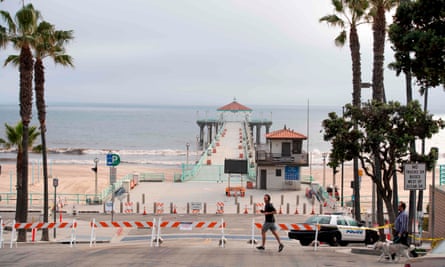 People walk by the closed pier, beach and strand in Manhattan Beach, California, on 28 April.