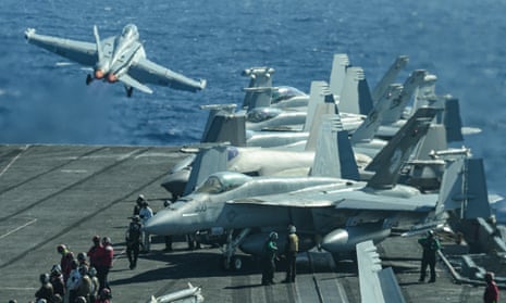 A F/A-18 fighter jet taking off from an aircraft carrier.