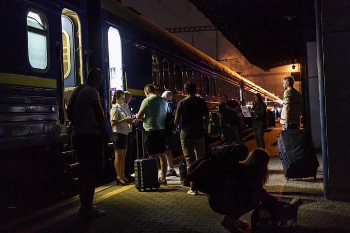 Passengers line up to board a night train heading west to Lviv from Kyiv on Tuesday 23 August.