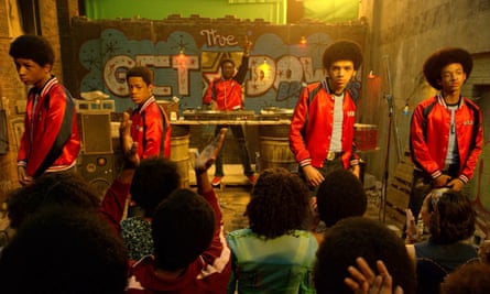 Five boys in matching NYC style jackets strike a hip-hop pose