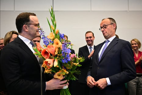 German chancellor Friedrich Merz is given a bouquet of flowers from Pparliamentary group leader of Germany’s Christian Democratic Union (CDU) Jens Spahn.