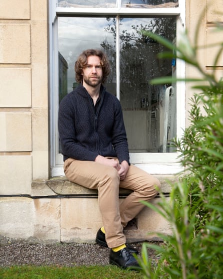 Christophe Fricker outside in a garden sitting on a windowsill