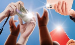 hands holding phones and cameras with flashing lights as a baby's hand reaches up