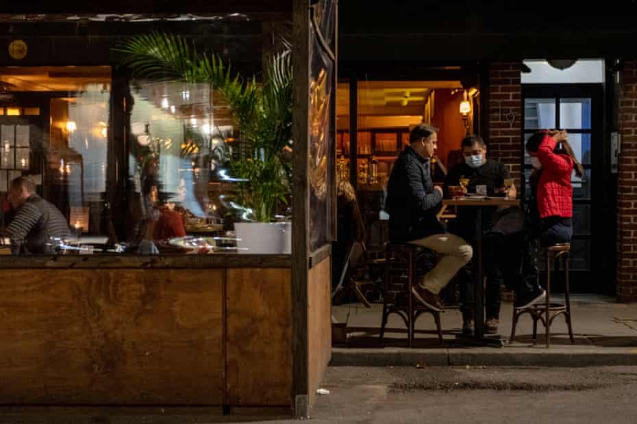 A waiter wearing a mask delivers food to customers dining outdoors in the West Village on 20 November 2020 in New York City. 