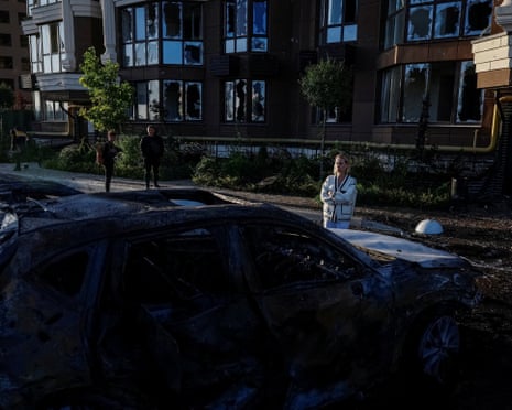 A resident looks at her damaged vehicle at the site of a Russian drone and missile strike in the outskirts of Kyiv, Ukraine, Saturday, 20 September 2025.
