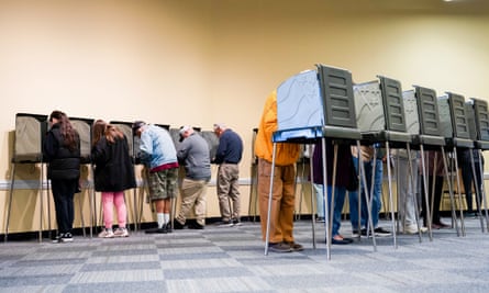 People voting in booths arranged in two lines