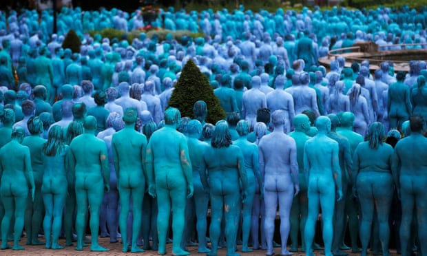 Nude models prepare to pose for a photograph.