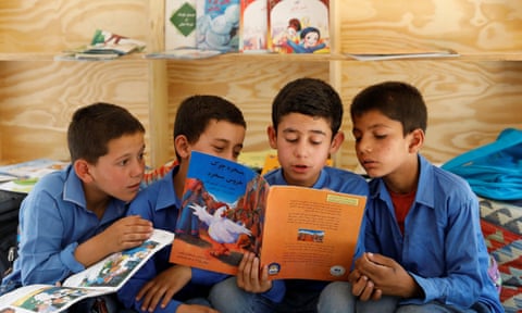 Afghan boys read books inside a mobile library bus in Kabul, Afghanistan.