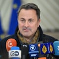 Luxembourg’s foreign minister Xavier Bettel with an array of media mics in foreground.