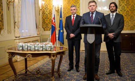 L to R: Gašpar, Fico and Kaliňák stand next to bundles of euros at the press conference.