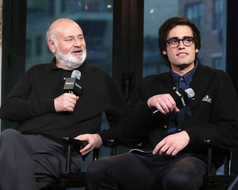 two men sitting next to each other and holding microphones