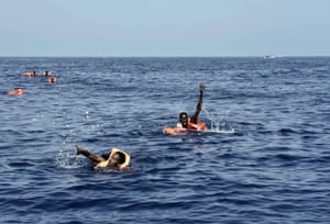 Migrants wave towards the rescuers