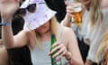 Teenage girl in summery wear enjoying a Heineken, face masked by a hat