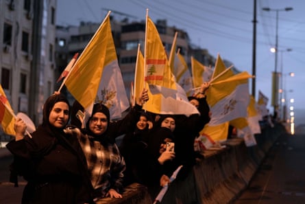 Women wave Lebanese and Vatican flags as the pope motorcade drives past in Beirut, Lebanon