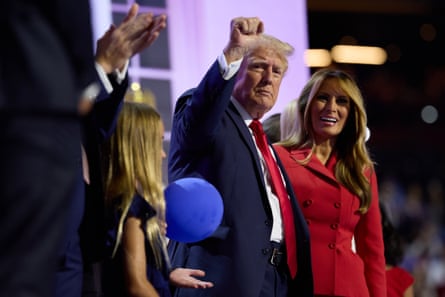 a man in a suit and tie holds up his fist
