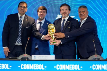 Paraguay's Robert Harrison, the Fifa delegate Ignacio Alonso, the Conmebol president Alejandro Dominguez and the Conmebol vice-president Claudio Tapia hold the World Cup in Luque, Paraguay, on Wednesday 4 October 2023