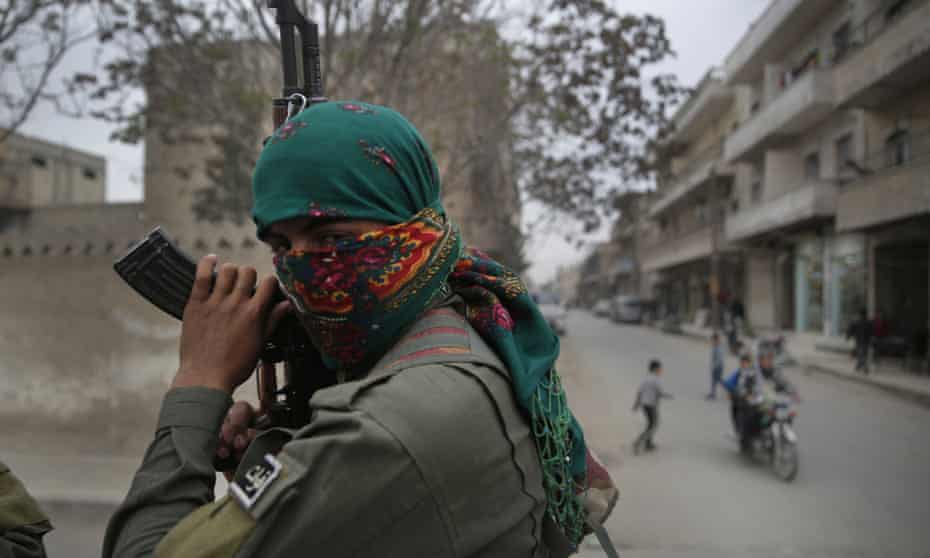 A Kurdish fighter patrols in Manbij