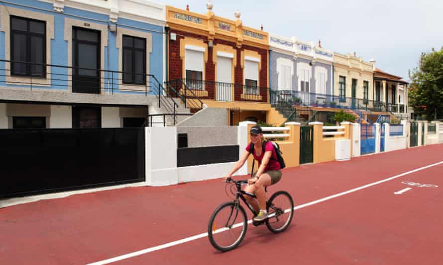 Uma mulher anda de bicicleta numa ciclovia em Espinho, Portugal.