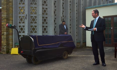 Rabbi Daniel Epstein intones funeral prayers over a shrouded coffin at Waltham Abbey cemetery, in Essex, on 7 May.