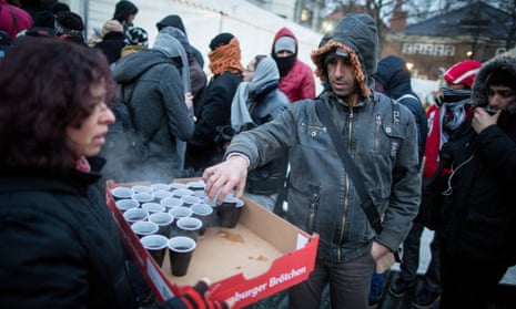 A volunteer serves coffee to migrants in Berlin.