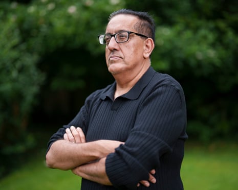 Nazir Afzal wearing a black top, stood in the garden, arms crossed