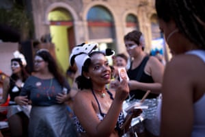 A woman in costume distributes stickers during the block party