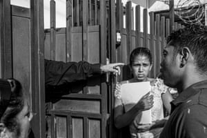 Asylum seekers wait at the gates of the Mexican Commission for Refuge for an asylum hearing in Tapachula, 18 June 2019