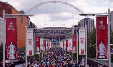Manchester United and Manchester City fans walk up Wembley Way towards the stadium.
