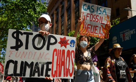 Protesters at a rally on the global day of action on climate change. One sign reads 'stop funding climate chaos' and the other says 'gas is a fossil fuel'.