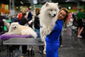 A woman cuddles her samoyed