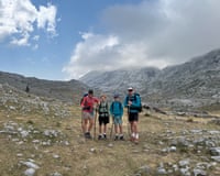 Family hiking in uplands and smiling at camera