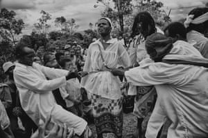 A person in white clothes is restrained by people around them