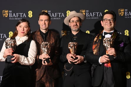 Lizzie Gillett, Robert Ford, Ian Bonhote dhe Peter Ettedgui duke mbajtur trofetë e BAFTA-s duke pozuar për fotografët