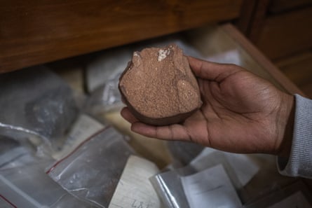 A round stone with a flat edge in the palm of a hand