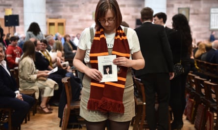 A mourner wearing a Hogwarts scarf holds the order of service for McKee’s funeral.