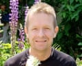 Andrew Cole smiles in a garden