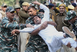 Security personnel detain a protester in New Delhi, India