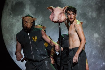 One dancer in a pig mask and another holding a pig’s head on a pole