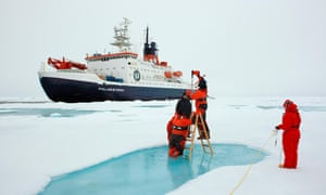 scientists bore into arctic sea ice, the polarstern behind them