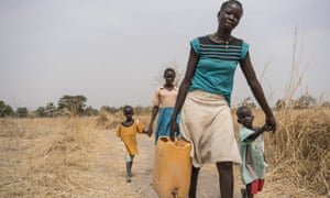 Abuk walks home after collecting clean water from a water point 4km away from her home.