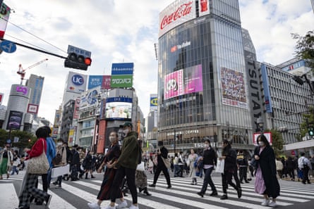 Locals and tourists pass each other at Tokyo's famous Shibuya Junction 