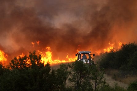 A tractor cuts a wildfire line