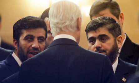 UN special envoy Staffan de Mistura (back to camera) speaks to the head of the Syrian opposition delegation Mohammed Alloush (right) before the talks