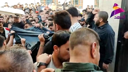 People carry bodies on Wednesday after members of Iraq’s Popular Mobilisation Forces were killed in strikes by the US.