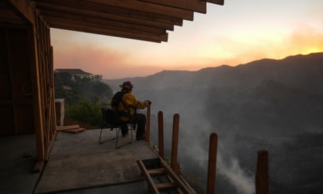 A firefighter rests as crews battle the Palisades Fire in Mandeville Canyon, Saturday, Jan. 11, 2025, in Los Angeles. (AP Photo/Eric Thayer)