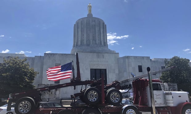 A truck moves around the Oregon state capitol in Salem on 12 June during a protest against climate bills that truckers say will put them out of business.
